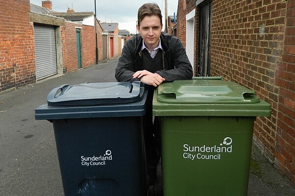 Niall Hodson with green and blue wheelie bins