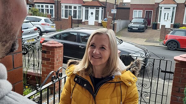 Julia Potts speaking to a resident on a doorstep in Thornhill