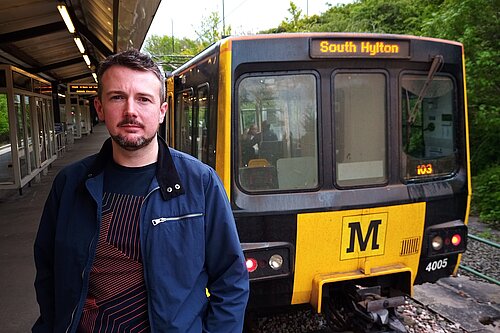 Martin Haswell stood in front of a Tyne and Wear Metro carriage