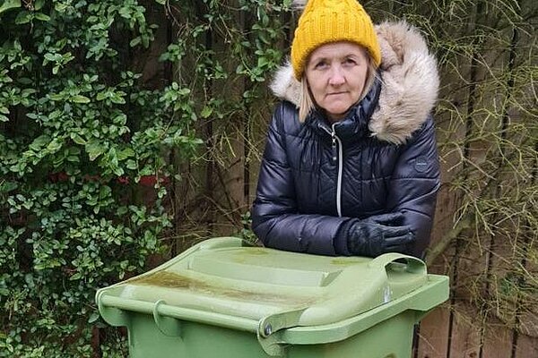Julia Potts with a green wheelie bin