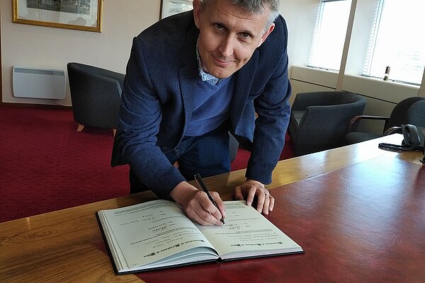 Councillor Andrew Wood signing an important document.